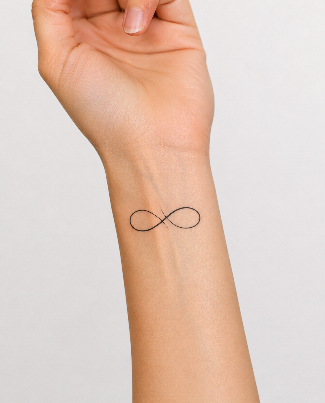Tatouage éphémère L’Infini symbole fineline sur poignet femme, encre jagua végétale